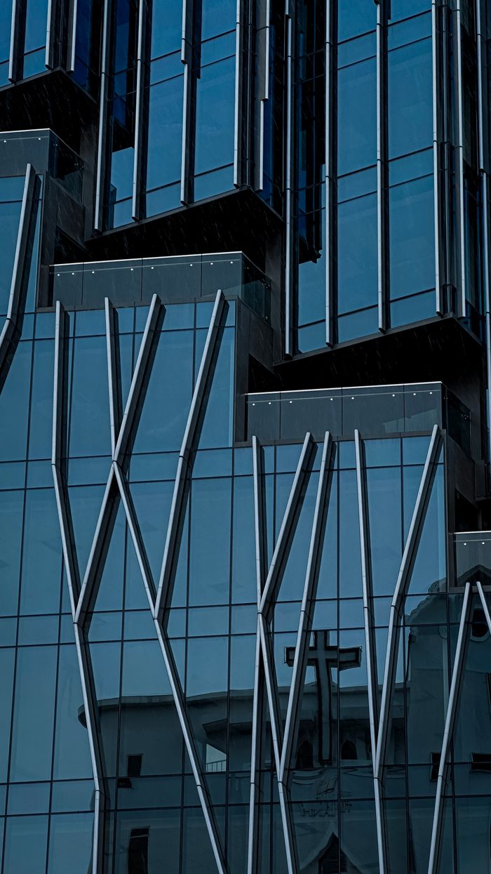 Reflective glass facade of modern building with architectural design elements in Vietnam.
